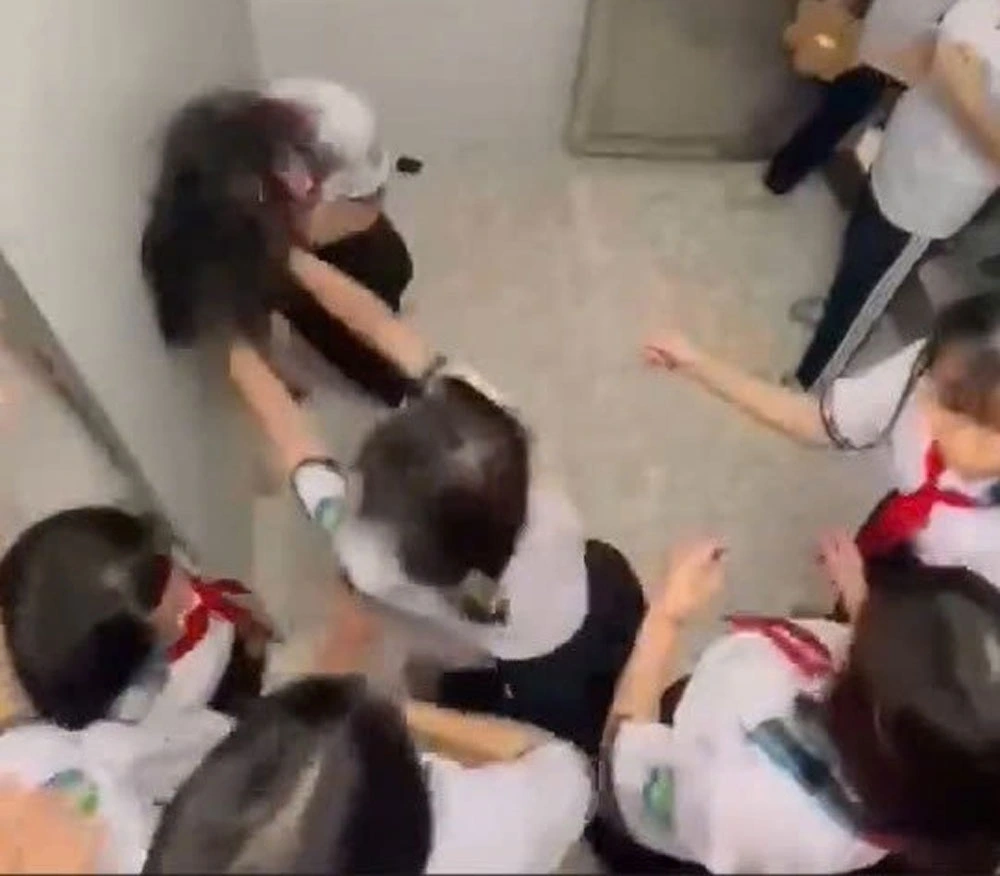 Nữ sinh đứng ôm đầu chịu trận