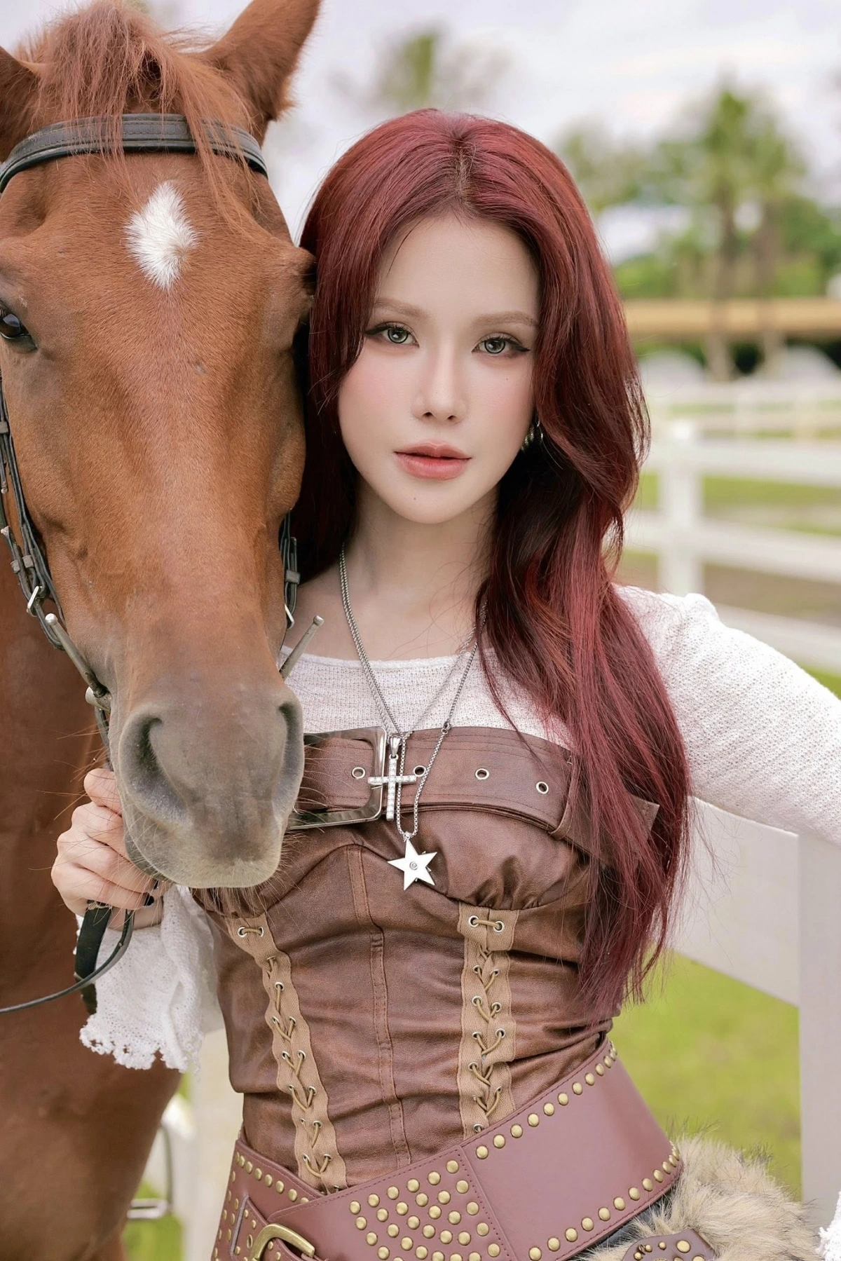 Diệp Lâm Anh chia sẻ loạt ảnh mới, hóa nữ cao bồi đi cưỡi ngựa. Cô diện áo dệt kim màu trắng kem, kết hợp cùng áo corset bằng da màu nâu với những chi tiết đan dây và đinh tán nổi bật.