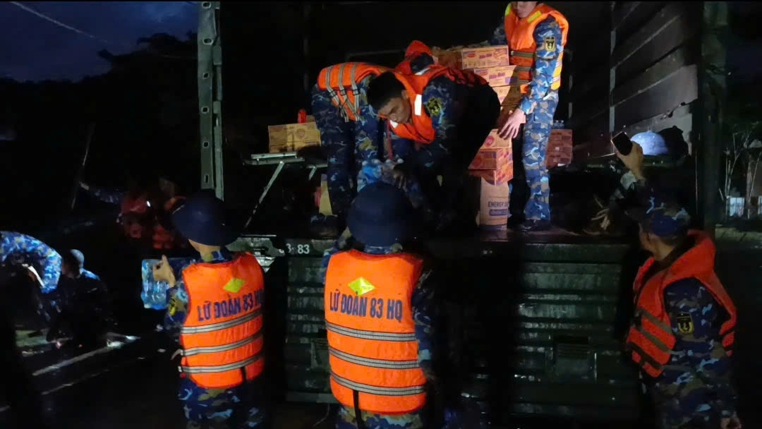 Cán bộ, chiến sĩ Lữ đoàn 83 vận chuyển mì tôm, nước ngọt và yếu phẩm tiếp tế cho nhân dân vùng ngập lụt. (Ảnh: Quân chủng Hải quân)