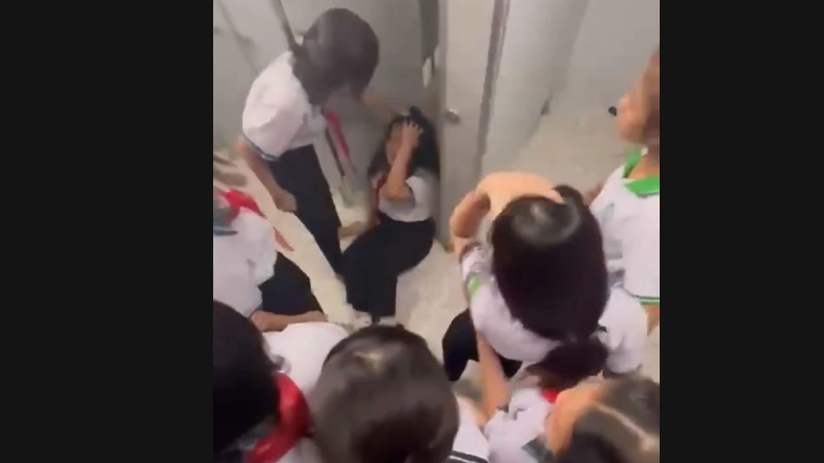 Nữ học sinh ôm đầu chịu trận