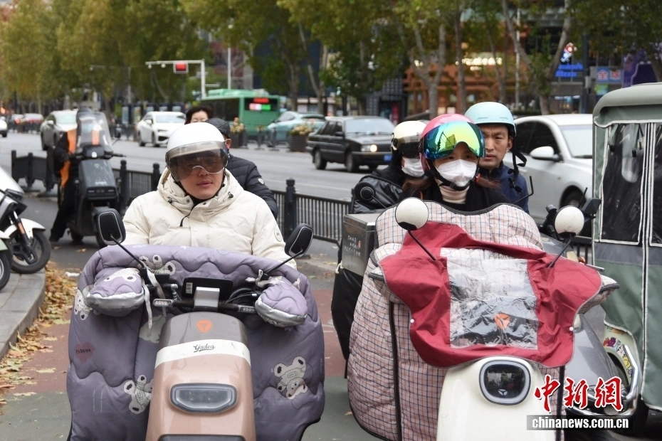 Người dân Trịnh Châu, tỉnh Hà Nam, miền Trung Trung Quốc trong trang phục mùa Đông ngày 17/11 khi một đợt không khí lạnh đang tấn công trên diện rộng ở nước này. Ảnh: China News