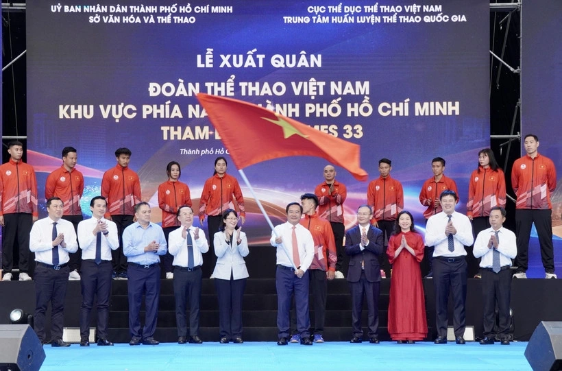 Chairman of the Ho Chi Minh City People’s Committee Nguyen Van Duoc (centre) waves the national flag at the ceremony