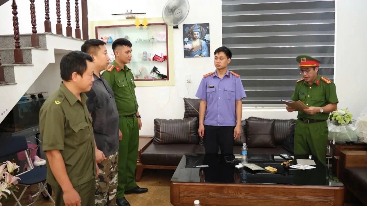 Cơ quan công an tống đạt quyết định khởi tố đối với Phạm Duy trong nhóm cho vay lãi nặng lãi. (Ảnh: Q.Văn)