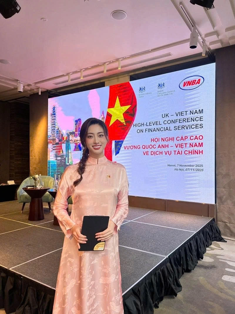 Hoa hậu Lương Thùy Linh mặc áo dài hồng, làm MC tại Hội nghị cấp cao Vương quốc Anh - Việt Nam về dịch vụ tài chính.
