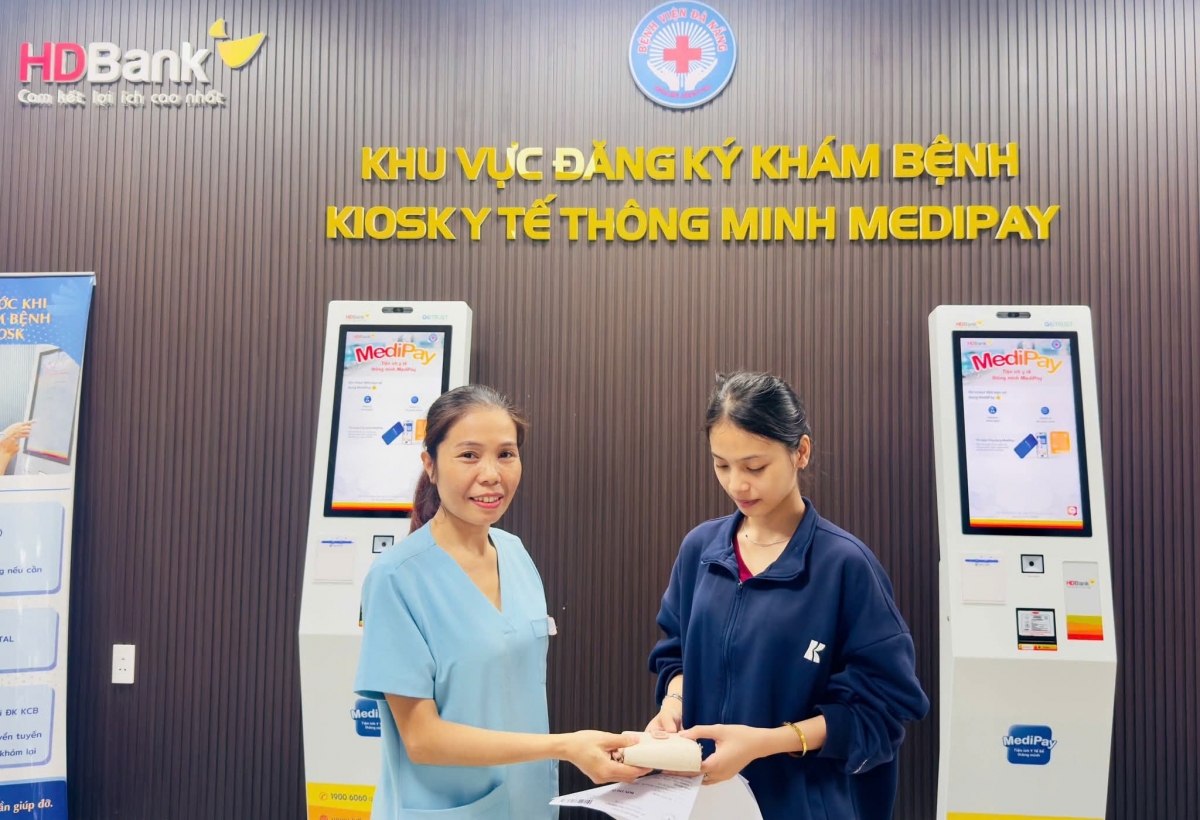 Nhân viên y tế bệnh viện Đà Nẵng (trái) trao tài sản trả lại người đánh rơi