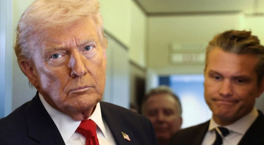 Tổng thống Mỹ Donald Trump cùng với Bộ trưởng Quốc phòng Pete Hegseth bên cạnh, đang phát biểu trước các phóng viên trên chuyên cơ Air Force One. Ảnh: Reuters
