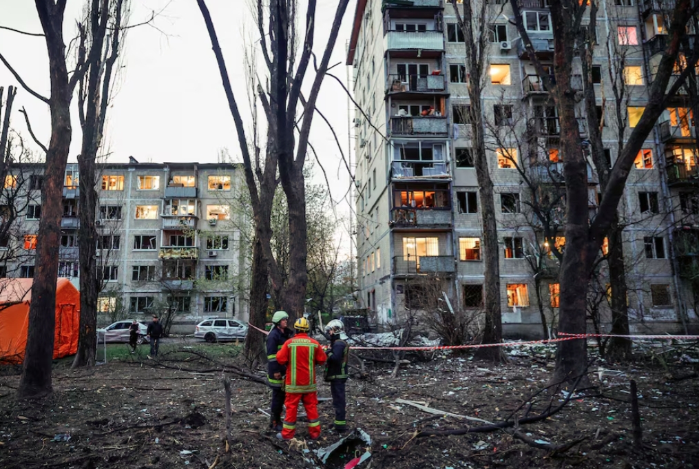 Lực lượng cứu hộ đứng gần các tòa nhà dân cư bị hư hại tại hiện trường vụ tấn công tên lửa của Nga, trong bối cảnh Nga tấn công Kiev, Ukraine ngày 16/4/2026. Ảnh: Reuters