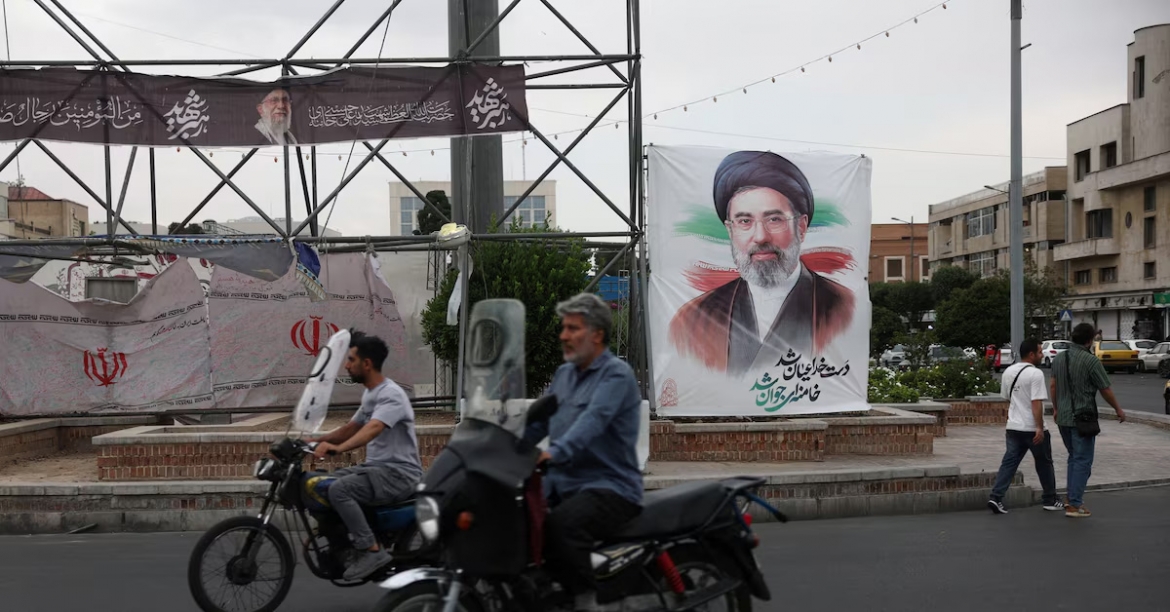 Người dân di chuyển trên một tuyến phố ở Tehran, gần tấm áp phích có hình ảnh Lãnh tụ Tối cao Iran Mojtaba Khamenei, ngày 7/6/2026. Ảnh: WANA/Reuters