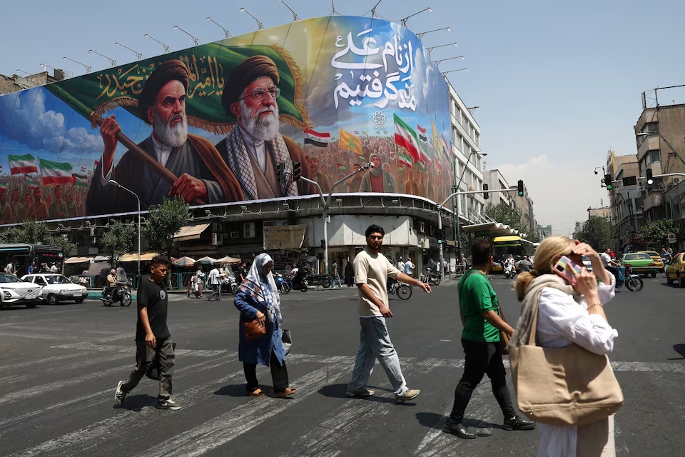 Người dân đi qua tấm biển có hình cố lãnh tụ Cách mạng Hồi giáo Ruhollah Khomeini và cố lãnh tụ tối cao Iran Ali Khamenei tại Tehran ngày 6/6/2026. Ảnh: WANA/Reuters