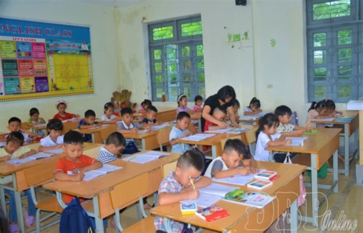 Giáo viên uốn từng nét chữ cho học sinh lớp 1 tại Trường phổ thông nội trú Tiểu học và THCS Thanh Yên. Ảnh: Nguyễn Hiền/Báo và phát thanh, truyền hình Điện Biên