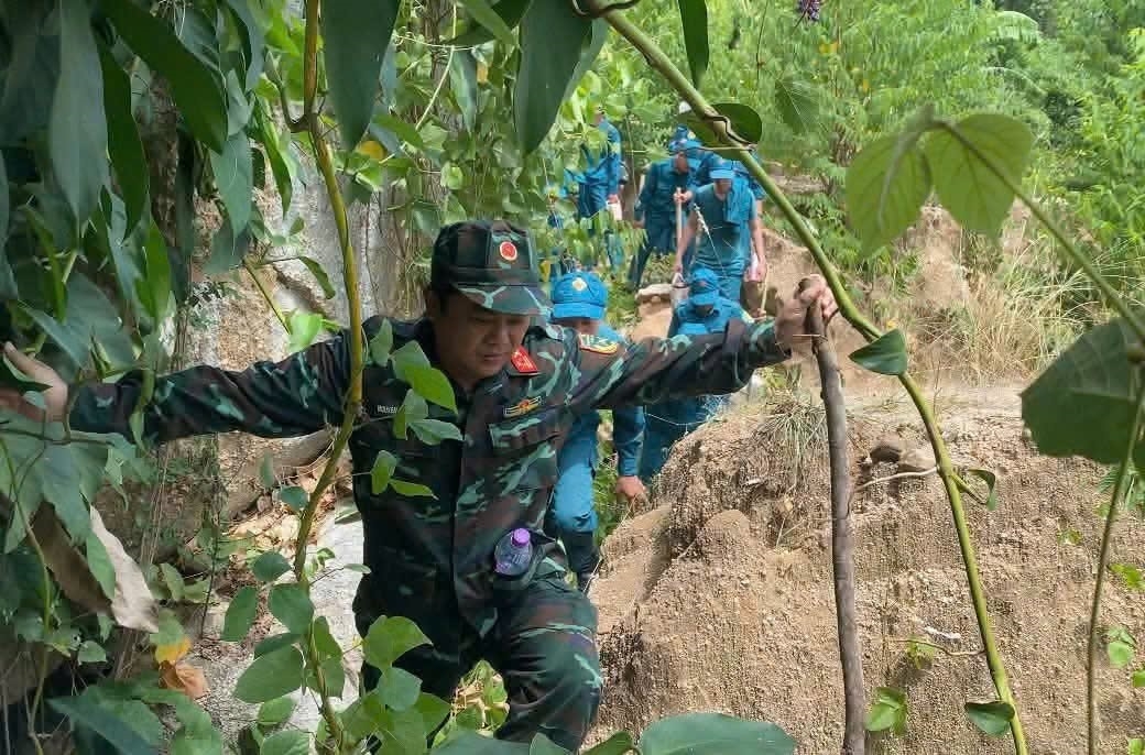 Lực lượng chức năng vượt qua khó khăn quy tập hài cốt liệt sĩ.