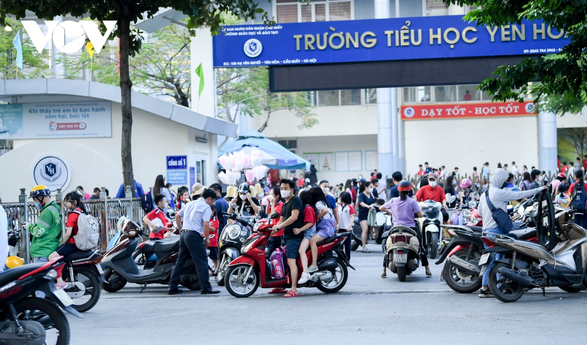 nhan nhan phu huynh dua don con de dau tran, vuot den do tren duong pho ha noi hinh anh 1