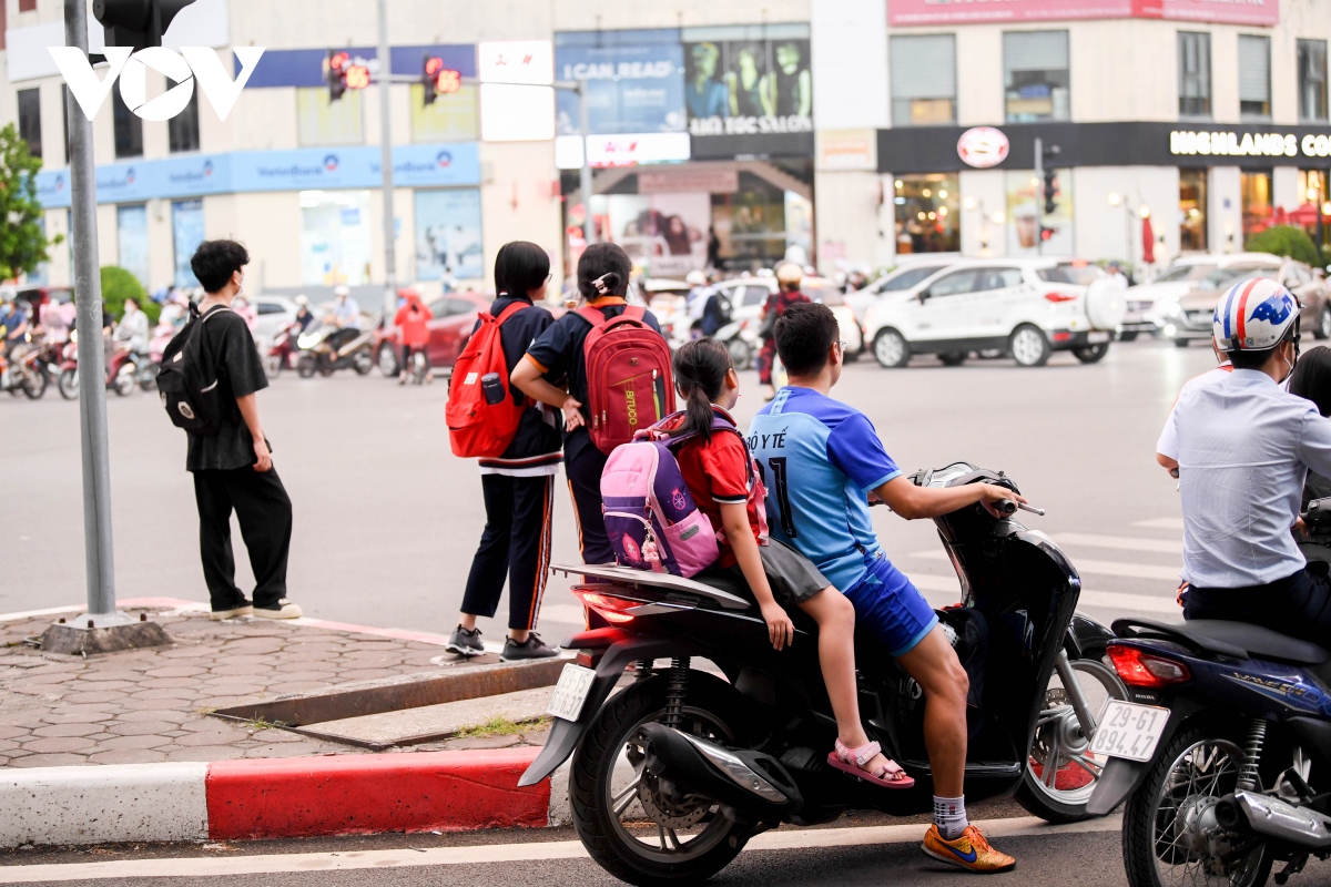 nhan nhan phu huynh dua don con de dau tran, vuot den do tren duong pho ha noi hinh anh 19
