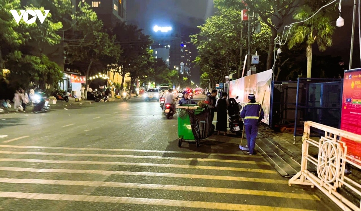 Công nhân môi trường thu gom rác thải tại khu vực khán đài sau đêm thi pháo hóa.jpg