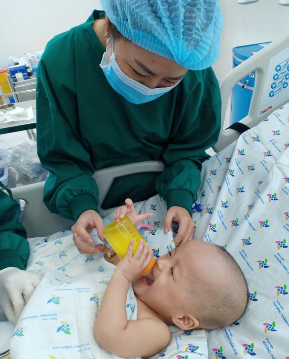 Trúc Nhi - Diệu Nhi tự cầm bình sữa uống, cười tít mắt khi thấy mẹ - Ảnh 1.