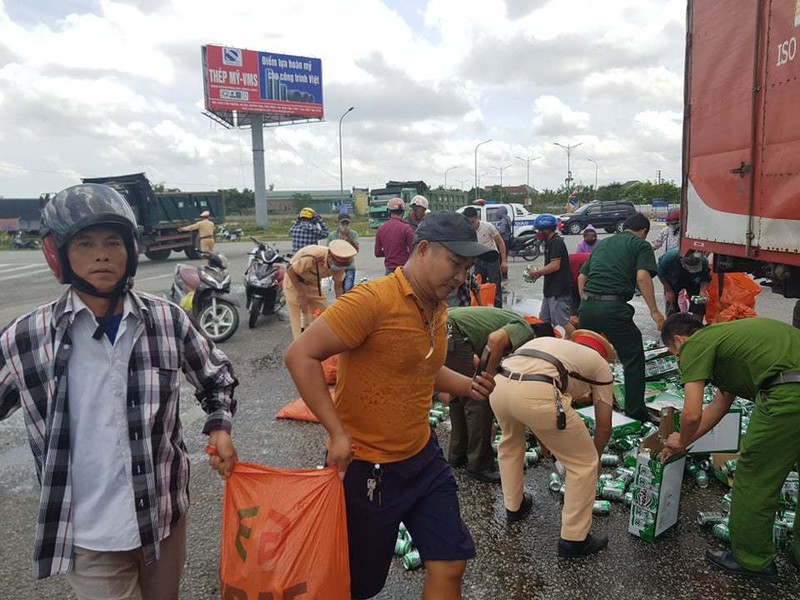 Xe tải chở bia đổ ra đường, công an cặm cụi gom giúp tài xế